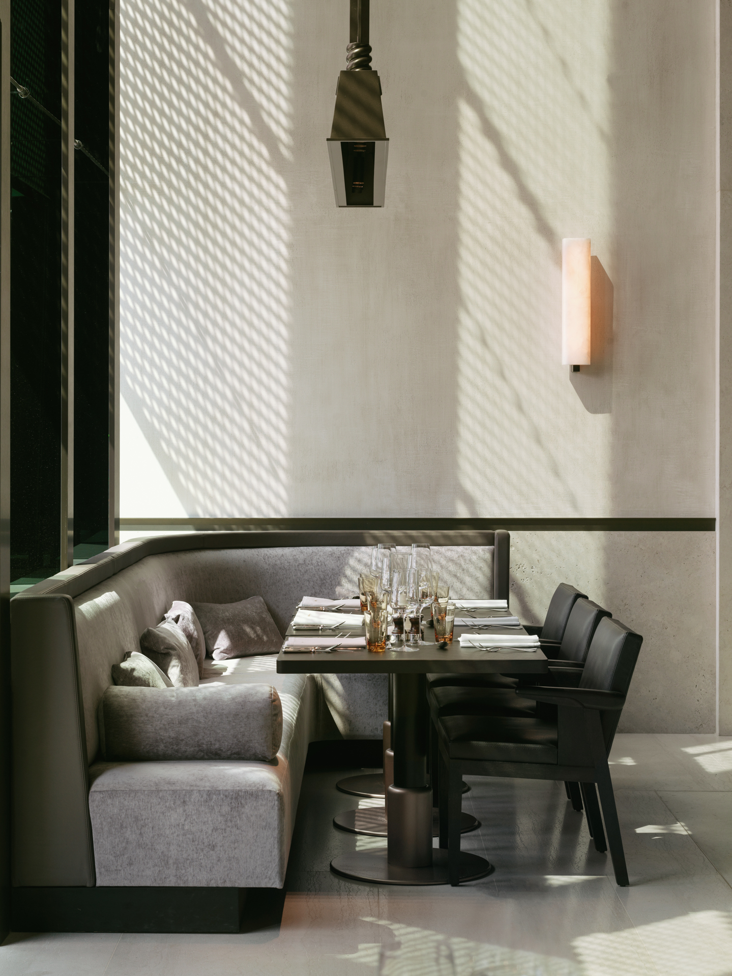 Een foto van een tafel en vast bankstel van het mooi interieur van restaurant La Rigue, ontworpen door architect Glenn Sestig in hotel La Réserve Resort 